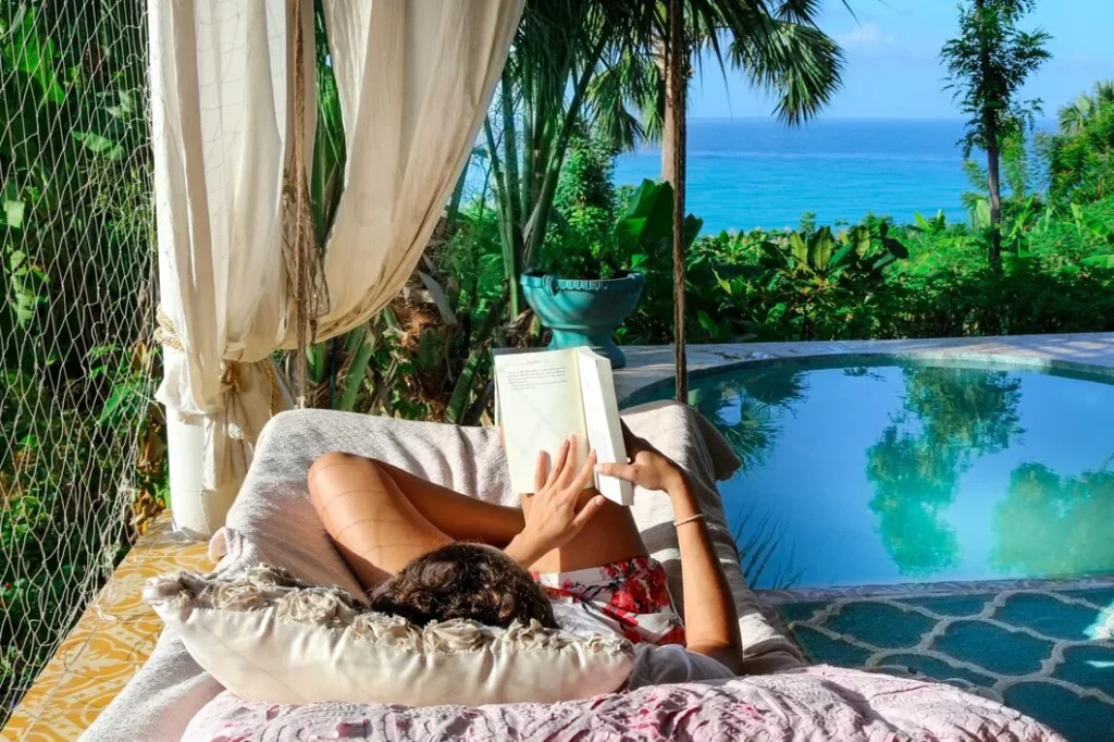 Woman relaxing at the beachfront while reading a book